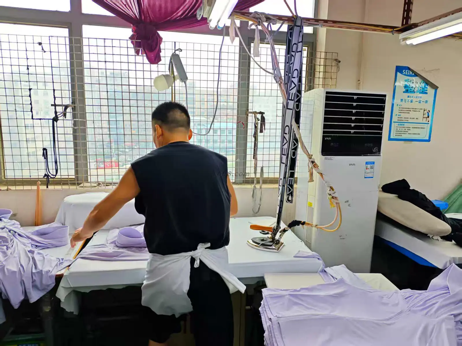 Garments being steam-ironed and finished at the finishing station